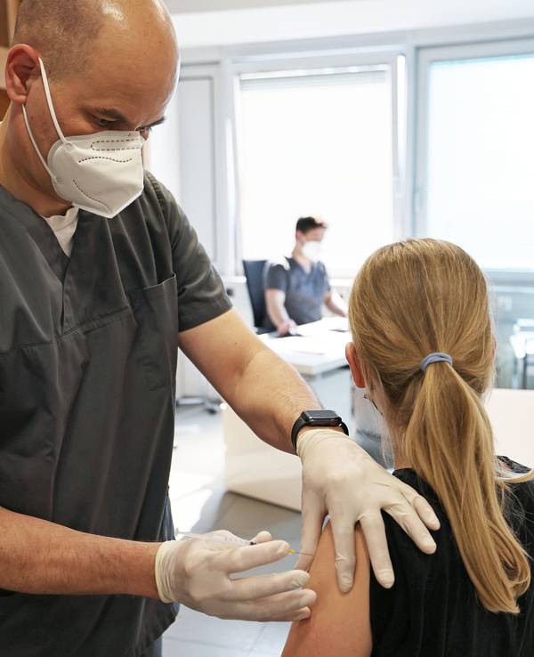 Kölner Ärzte wollen aus der Impfkampagne aussteigen. Auf diesem Foto impft ein Arzt in einer Praxis ein Mädchen gegen das Coronavirus.