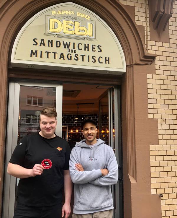 Moritz Issinger und Saloum Doucouré stehen vor dem Eingang ihres Delis in der Kölner Südstadt.