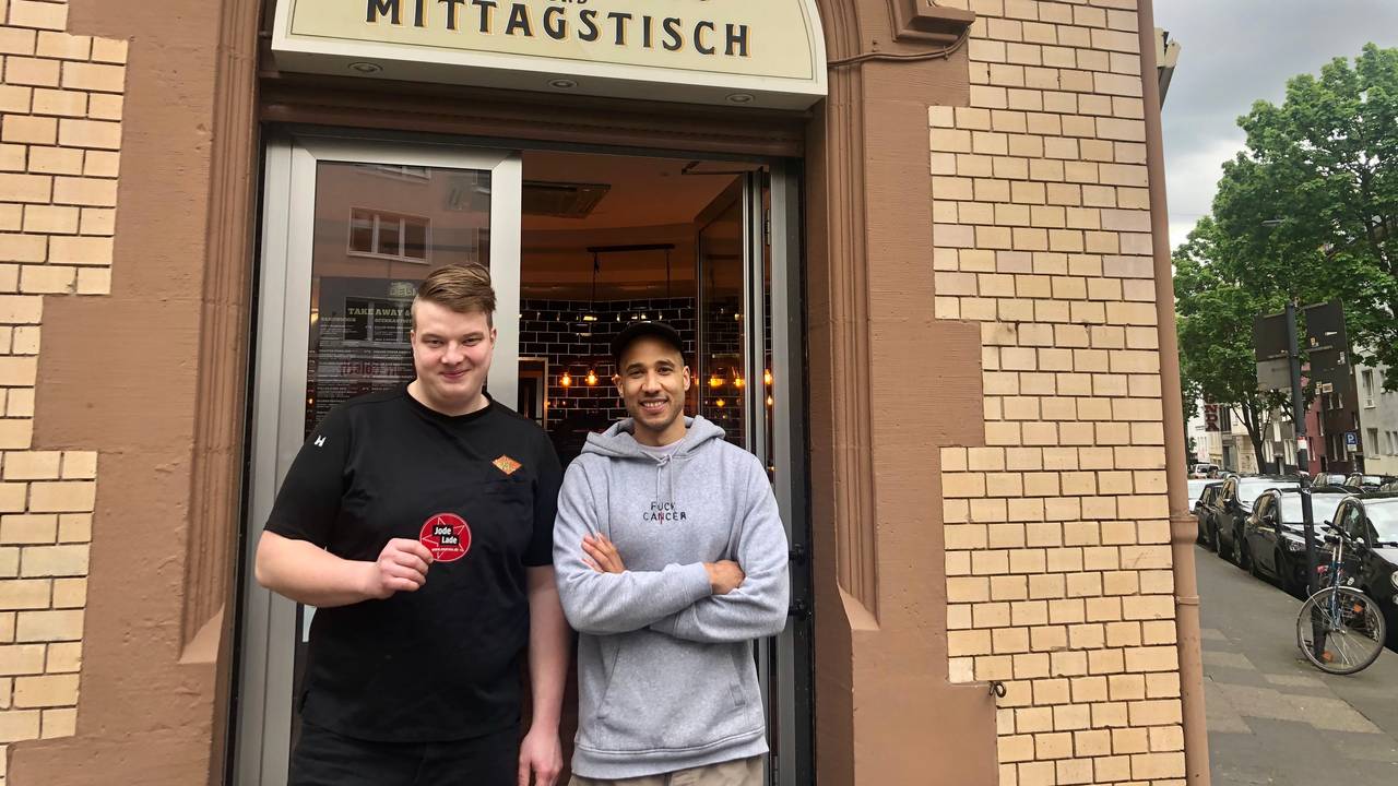 Moritz Issinger und Saloum Doucouré stehen vor dem Eingang ihres Delis in der Kölner Südstadt.