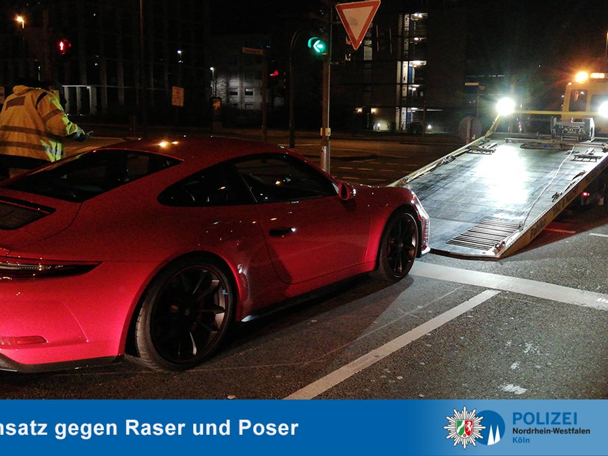 Ein Abschlepper hat einen roten Porsche am Haken.