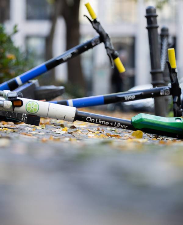 E-Scooter liegen auf einem Gehweg und versperren den Weg.