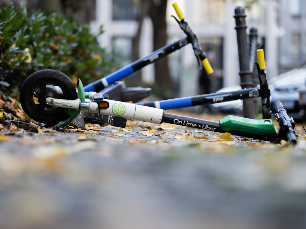 E-Scooter liegen auf einem Gehweg und versperren den Weg.