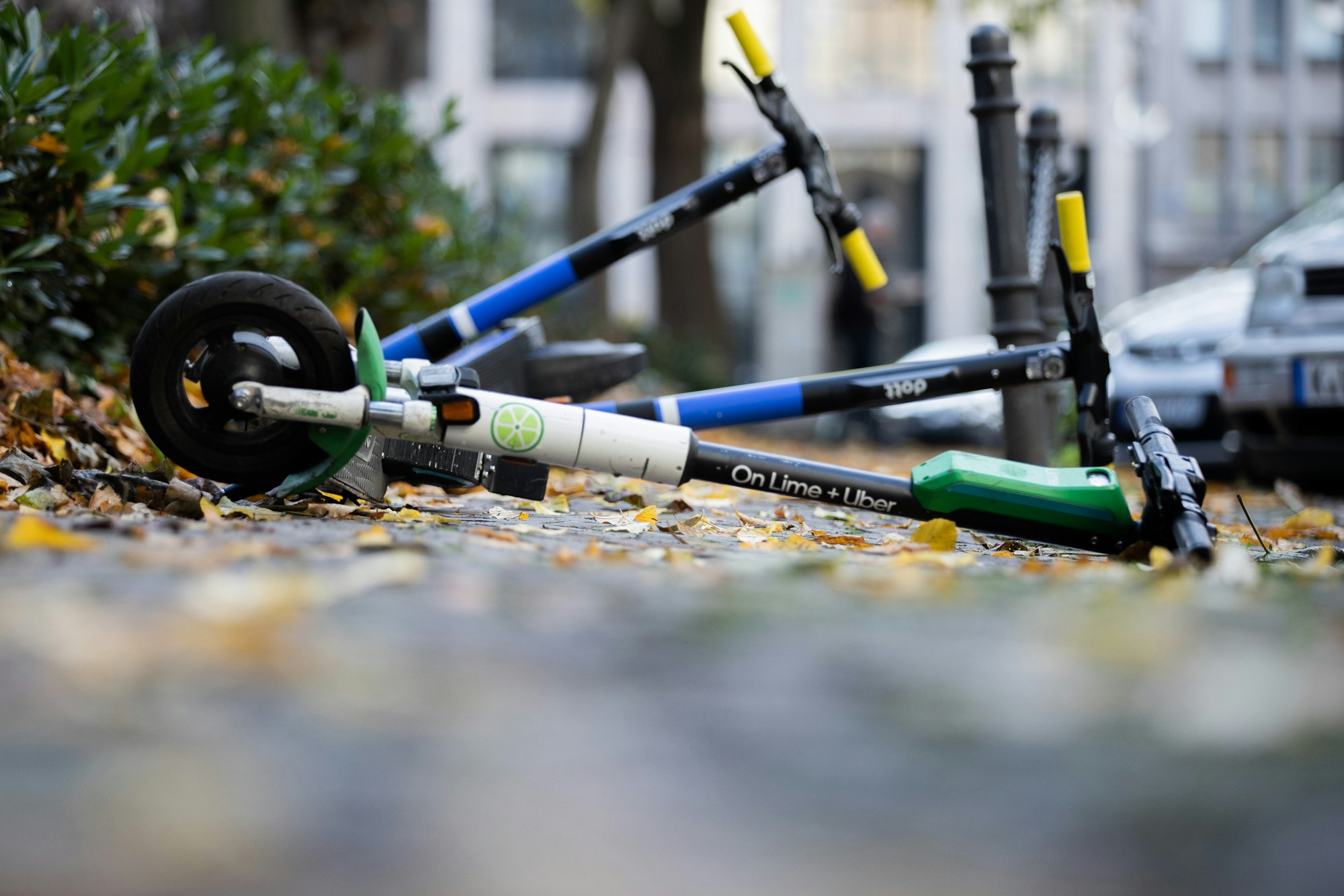 E-Scooter liegen auf einem Gehweg und versperren den Weg.
