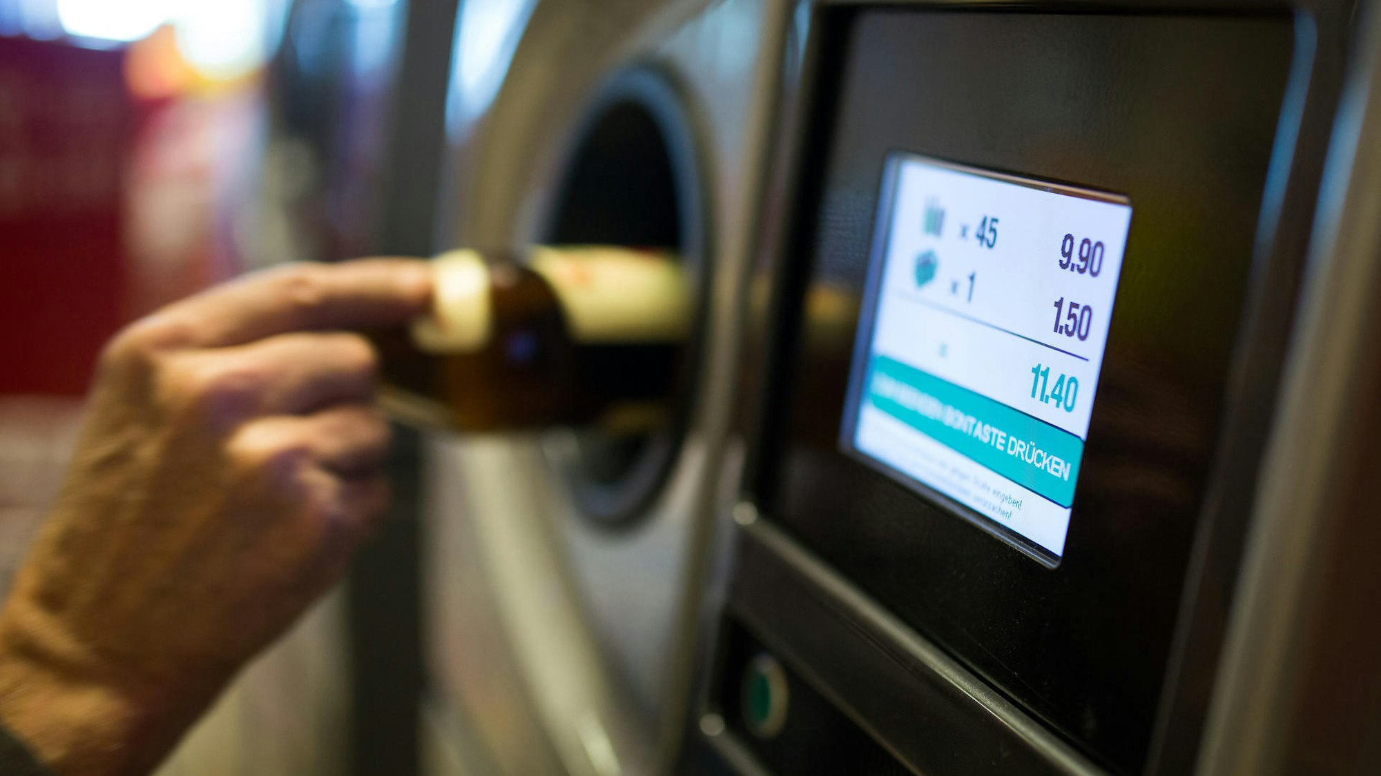 Eine ältere Dame steckt eine Flasche in den Leergutautomaten eines Supermarktes, ein Preis wird in einem Display angezeigt: Ein Hinweis an solch einem Leergutautomaten in einer Edeka-Filiale sorgte für einen Shitstorm im Netz, das Unternehmen distanzierte sich sofort.