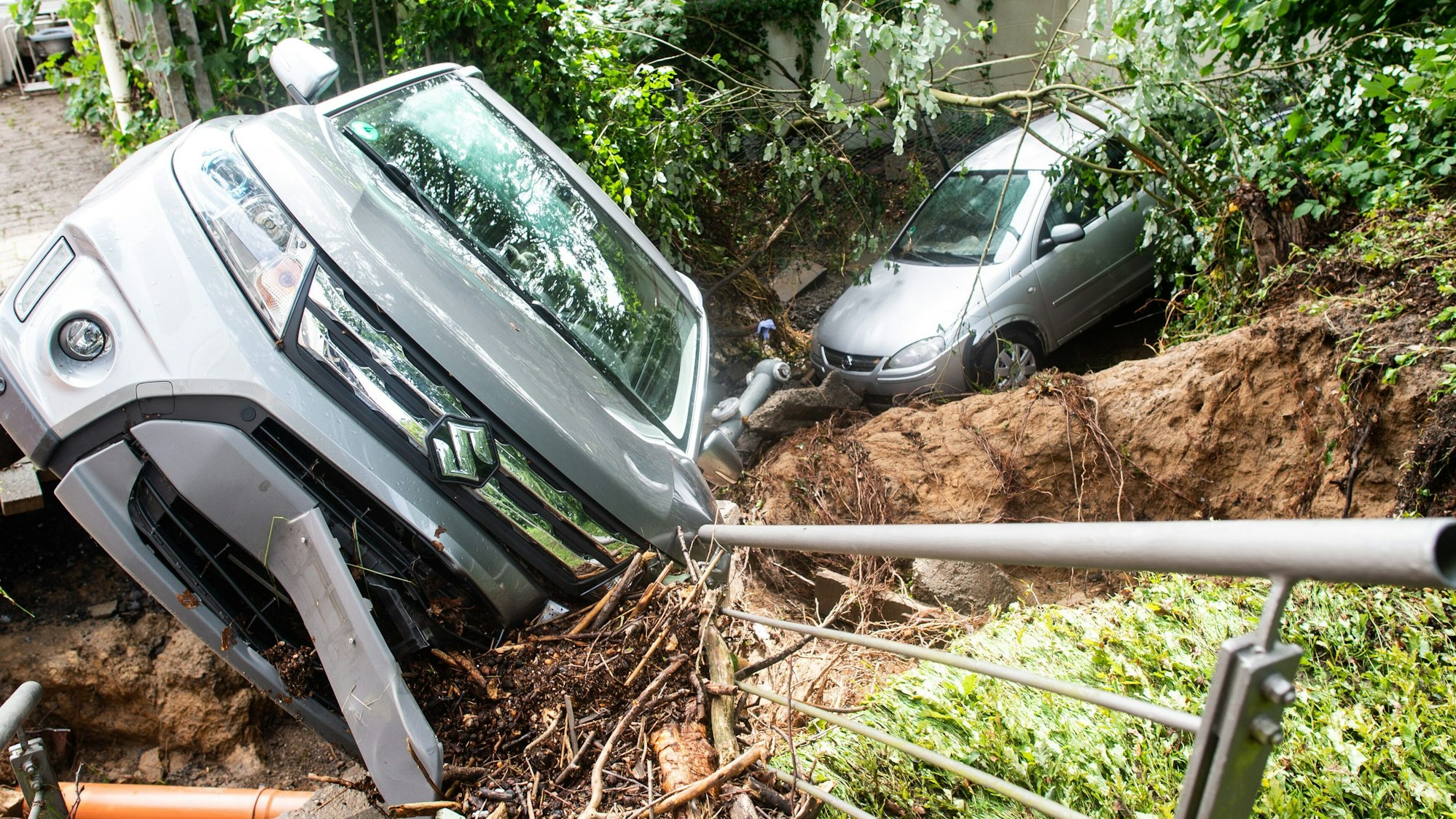 05.07.2021, Nordrhein-Westfalen, Fröndenberg/Ruhr: Zwei weggespülte Autos liegen in einem Bachlauf am Neuapostolischen Seniorenzentrum. Am Abend zuvor und in der Nacht zu Montag zog ein Unwetter über Nordrhein-Westfalen, das für zum Teil heftige Schäden gesorgt hat. Foto: Jonas Güttler/dpa +++ dpa-Bildfunk +++
