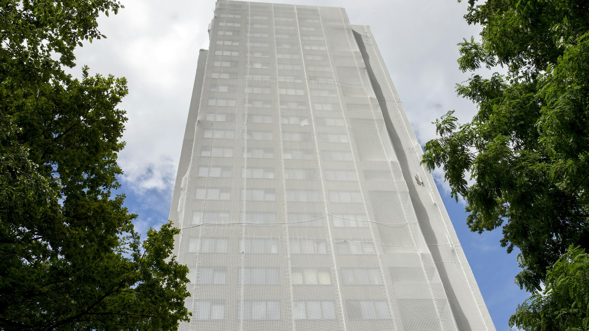 Der Wohnturm in Köln-Müngersdorf ist von einem großen Netz umhüllt.