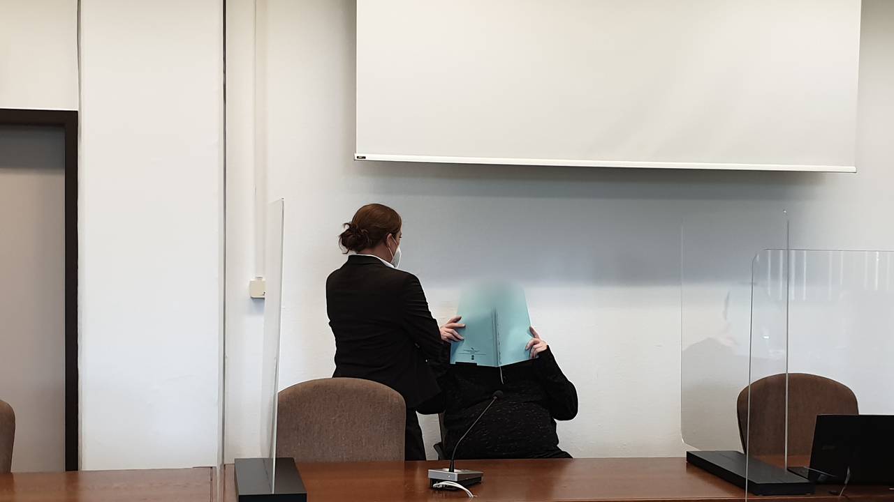 Vor dem Kölner Landgericht hält sich der Angeklagte eine Akte vor sein Gesicht.