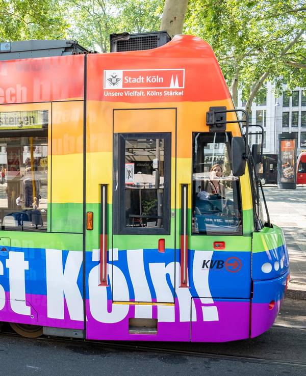 Eine bunte Regenbogen-Bahn der KVB fährt durch Köln.