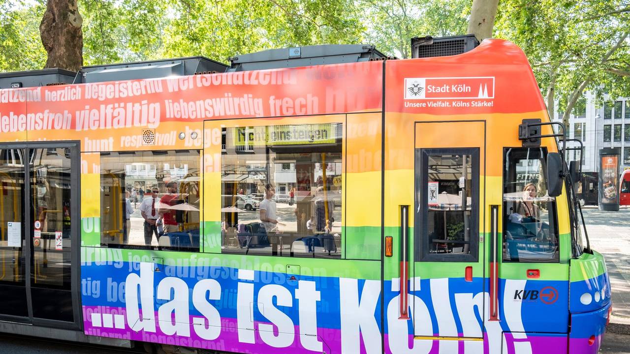 Eine bunte Regenbogen-Bahn der KVB fährt durch Köln.
