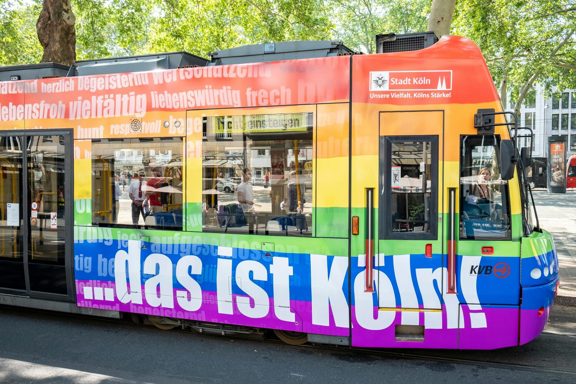 Eine bunte Regenbogen-Bahn der KVB fährt durch Köln.