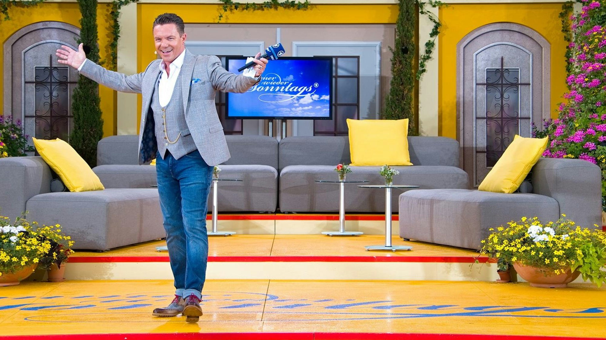 Das Foto zeigt die ARD-Fernsehsendung "Immer wieder Sonntags" mit Stefan Mross aus dem Europa-Park, der Moderator steht auf der Bühne und begrüßt das Publikum.