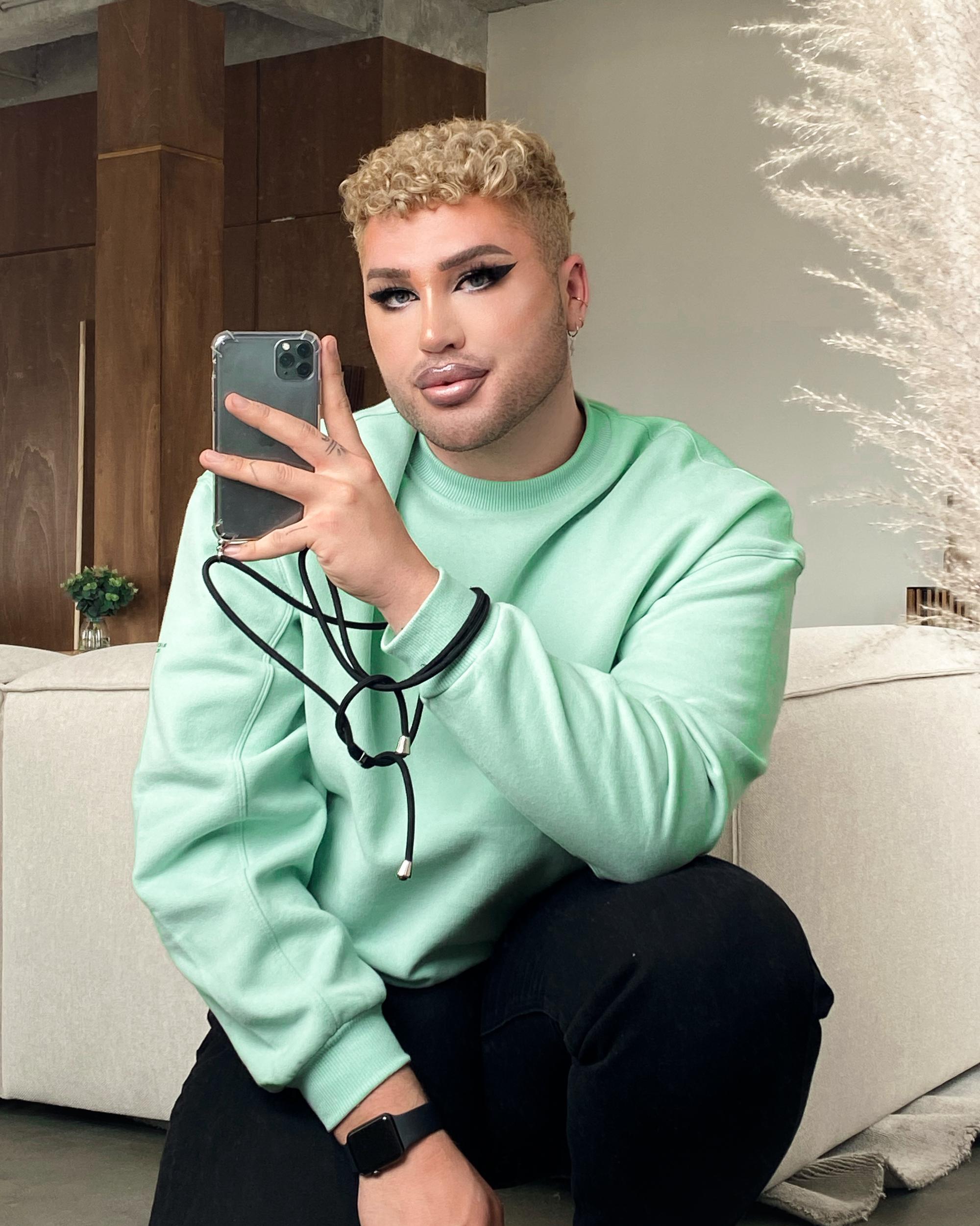 Auf dem Foto ist der Kölner Influencer David Lovric (24) geschminkt mit seinem Smartphone abgebildet.