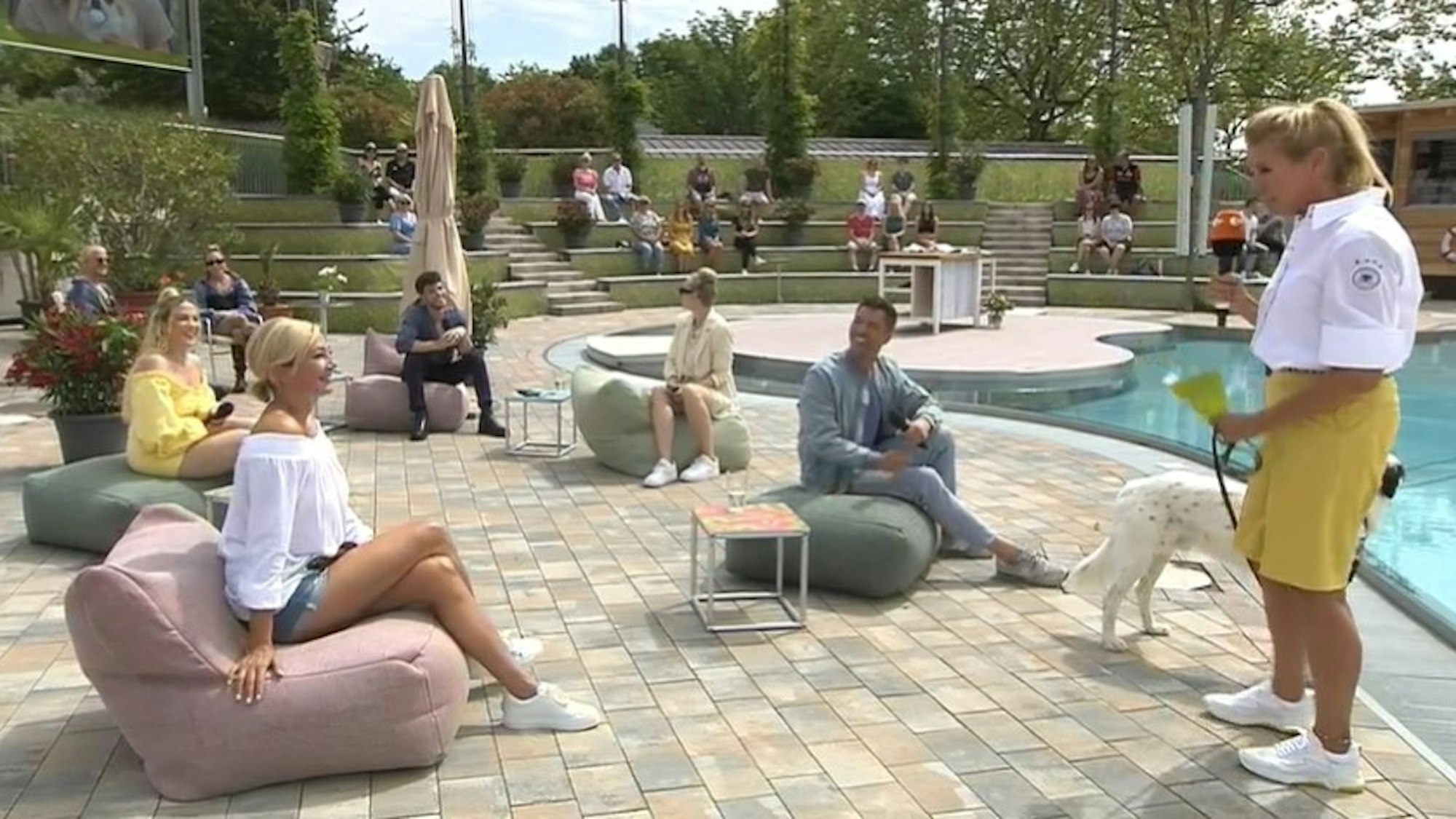 Andrea Kiewel begrüßt am 27. Juni im ZDF-„Fernsehgarten“ ihre Gäste. Sie trägt dabei eine weiße Bluse mit einem dem Trikot-Emblem der deutschen Fußballnationalmannschaft ähnlichen Aufnäher. Das sorgte für Diskussionen.