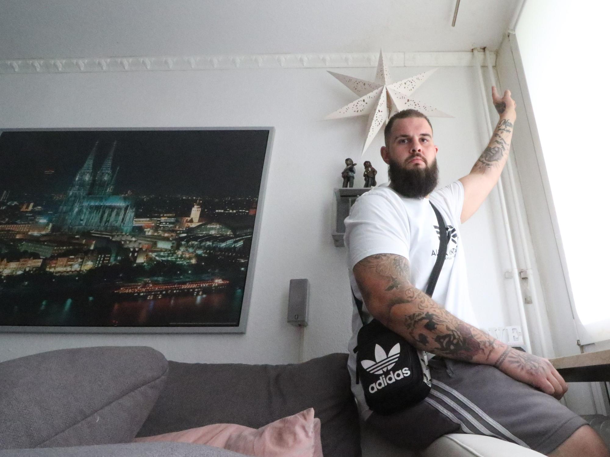 Mieter Dennis Linnartz zeigt auf eine undichte Stelle in seiner Wohnung.
