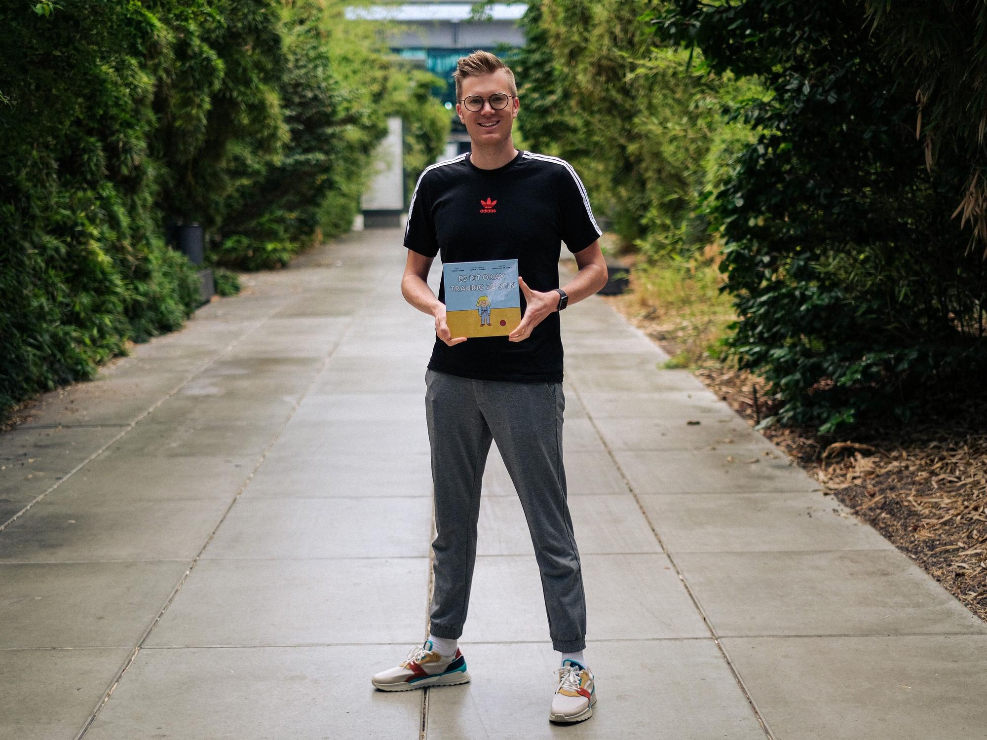 Tobias Budde zeigt sein Buch „Es ist okay, traurig zu sein“.