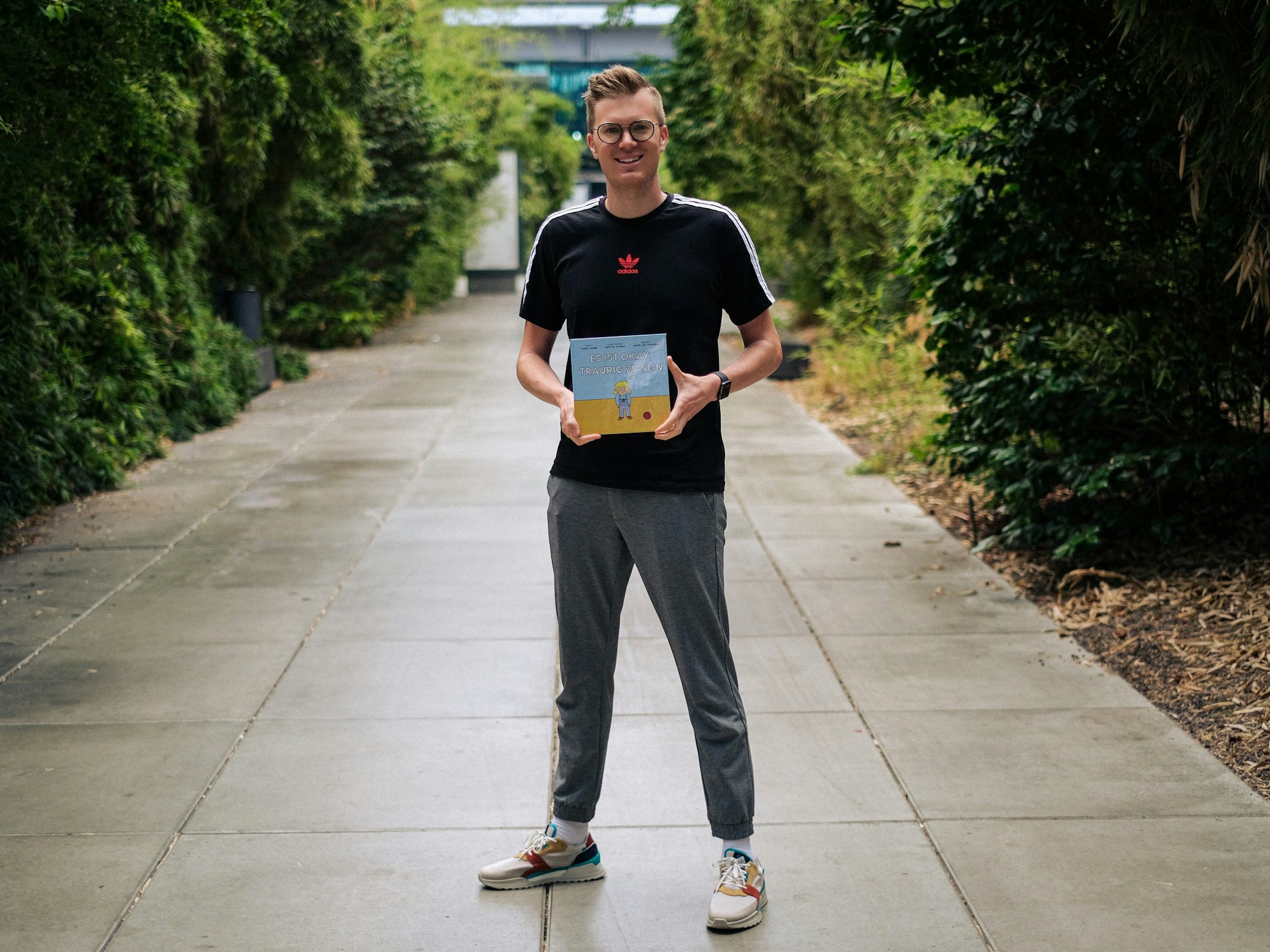 Tobias Budde zeigt sein Buch „Es ist okay, traurig zu sein“.