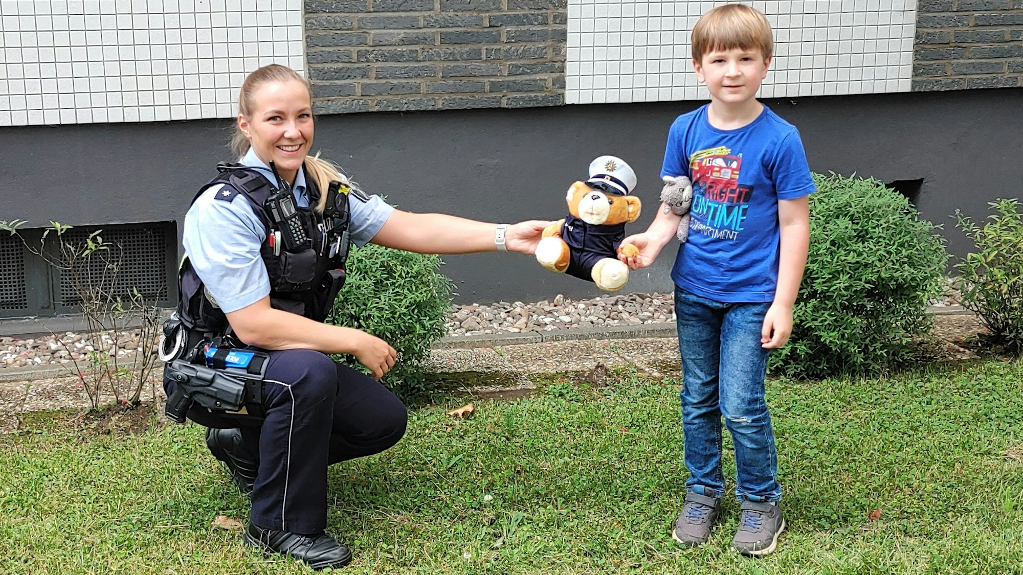 Streifenpolizistin Lynn S. überreicht Klaas einen Polizei-Teddy.