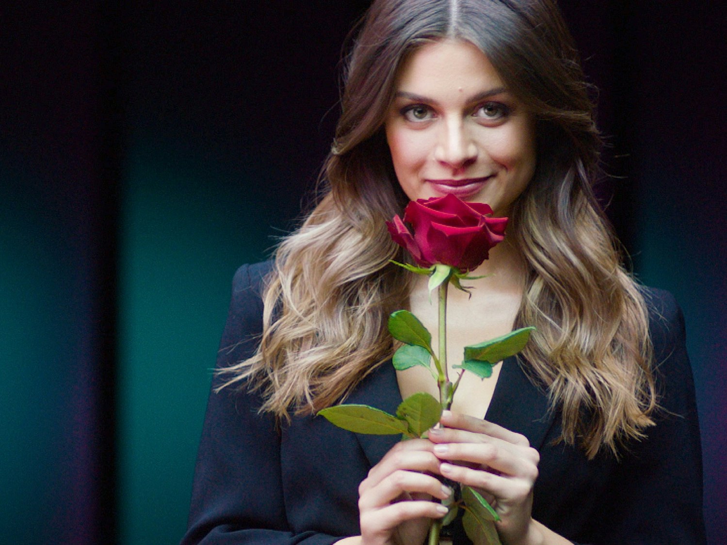 Bachelorette Maxime Herbord hält eine Rose in der Hand.