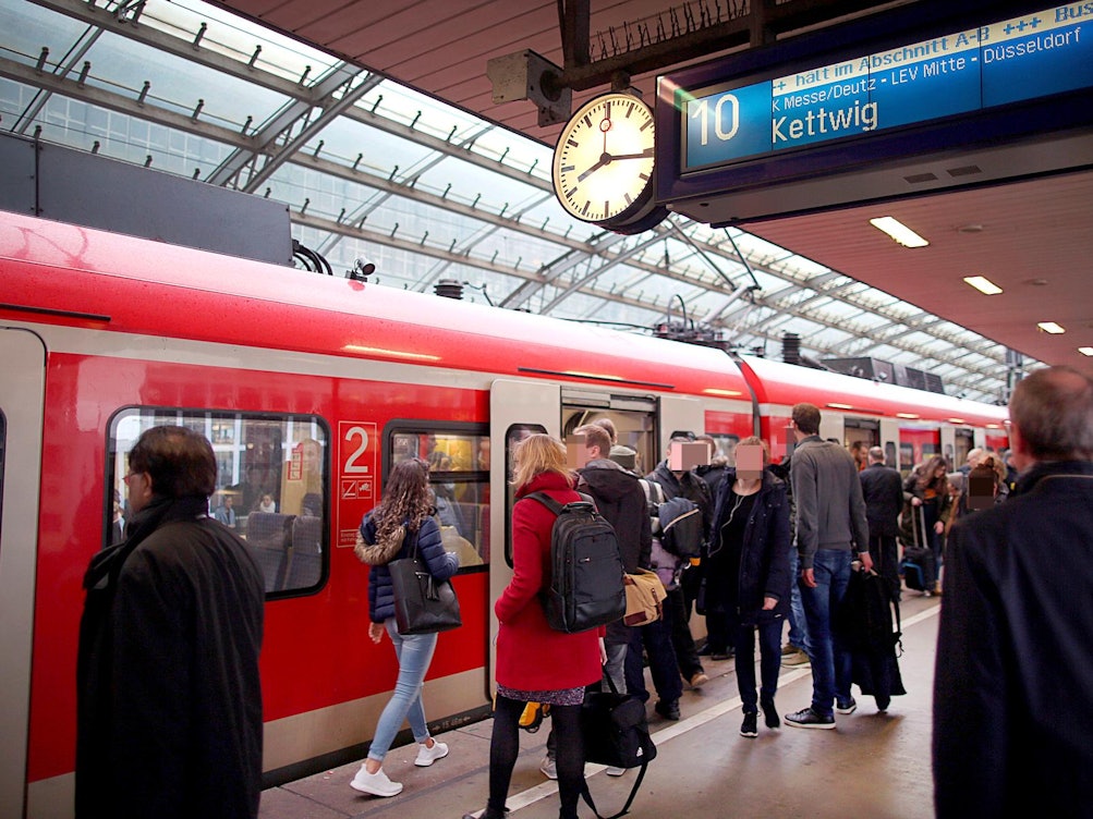 Fahrgäste an einem Zug im Kölner Hauptbahnhof.
