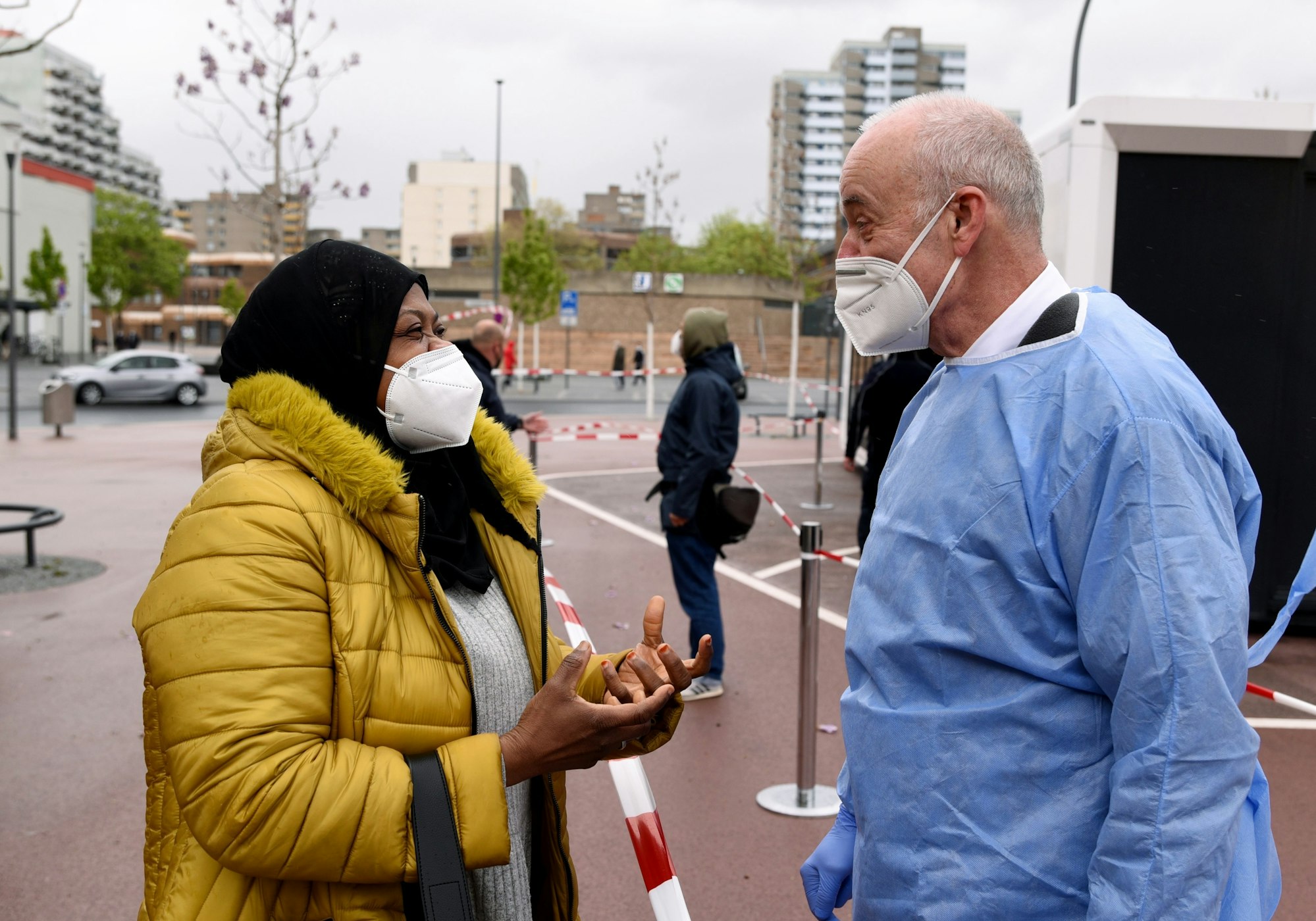 Der leitende Kölner Impfarzt Jürgen Zastrow bei der mobilen Impfaktion in Köln-Chorweiler im Gespräch mit einer Frau.