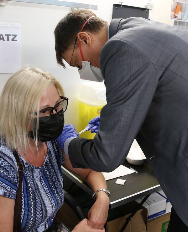 In Köln-Mülheim impft der SPD-Politiker Karl Lauterbach eine Frau im mobilen Impfzentrum.