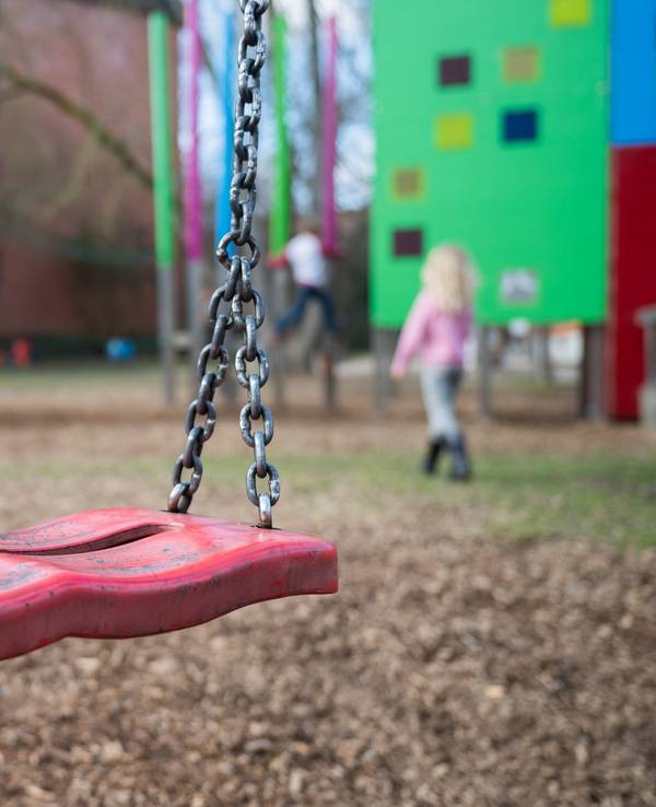 Eine Schaukel hängt auf einem Kinderspielplatz.