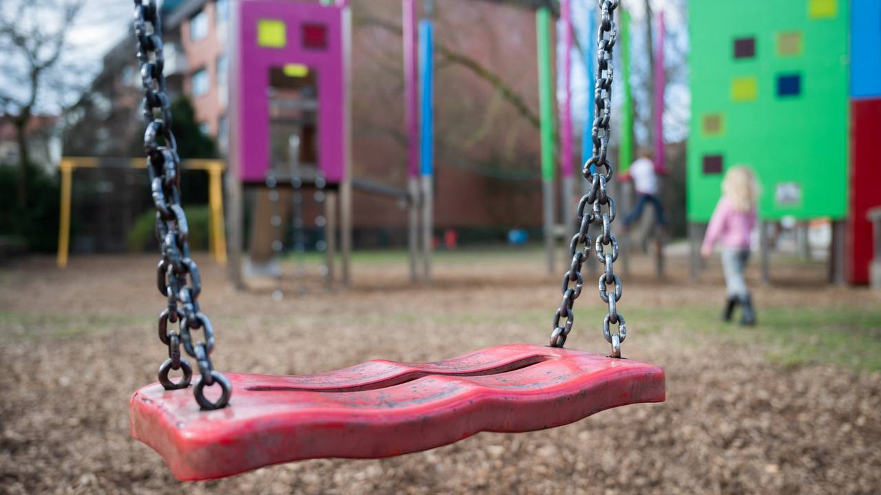 Eine Schaukel hängt auf einem Kinderspielplatz.