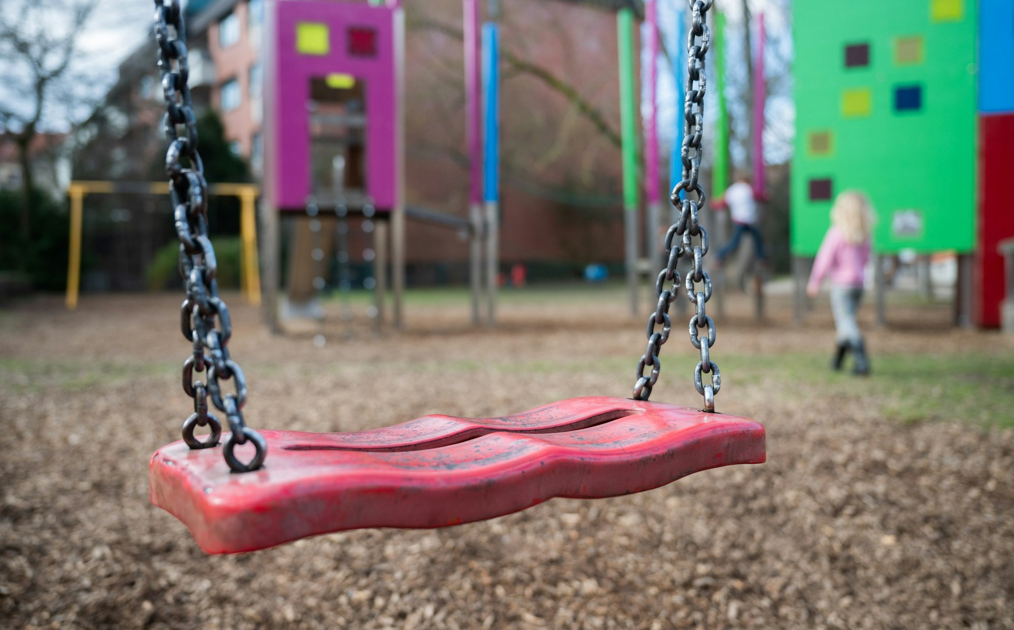 Eine Schaukel hängt auf einem Kinderspielplatz.