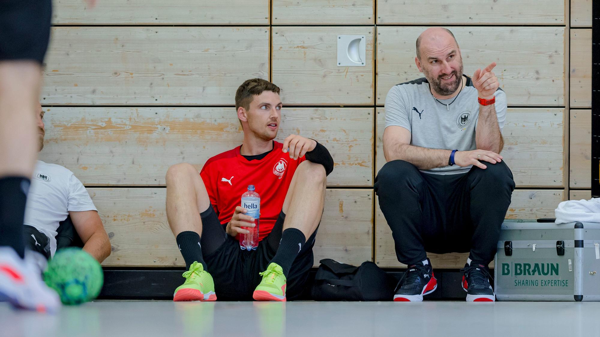 Co-Trainer Erik Wudtke vom Deutschen Handball-Bund im Gespräch mit Nationalspieler Hendrik Pekeler von THW Kiel.