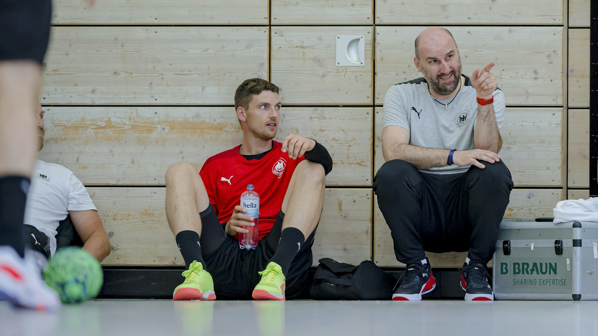 Co-Trainer Erik Wudtke vom Deutschen Handball-Bund im Gespräch mit Nationalspieler Hendrik Pekeler von THW Kiel.