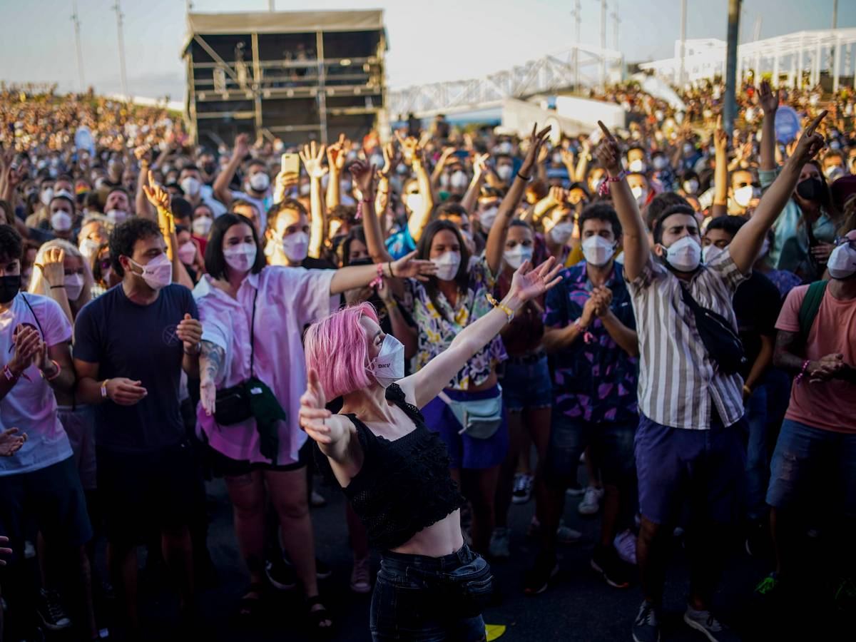Menschen mit Mund-Nasen-Schutz besuchen das Cruilla Musikfestival in Barcelona und feiern.