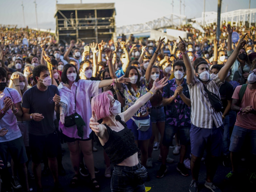 Menschen mit Mund-Nasen-Schutz besuchen das Cruilla Musikfestival in Barcelona und feiern.
