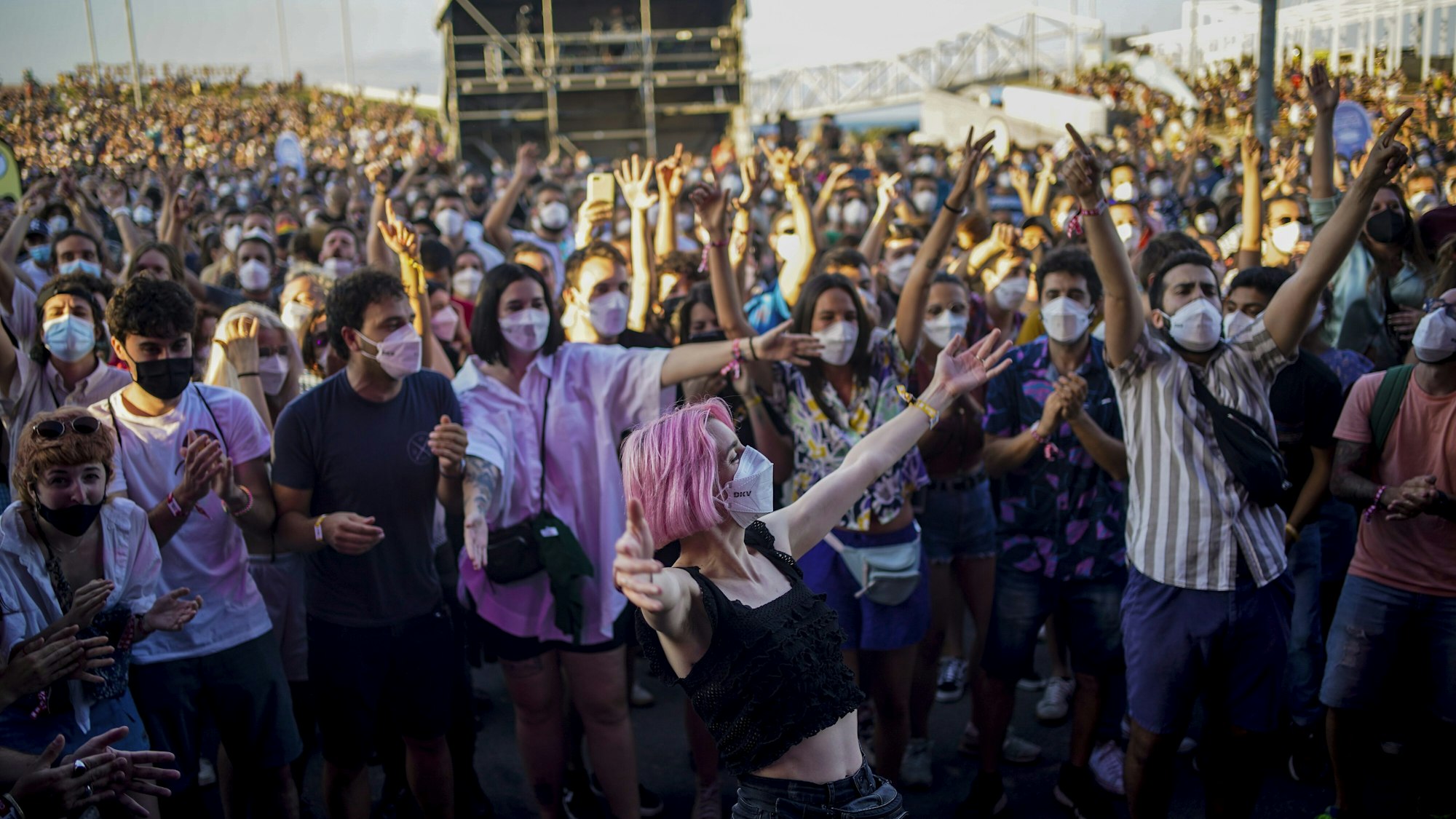 Menschen mit Mund-Nasen-Schutz besuchen das Cruilla Musikfestival in Barcelona und feiern.