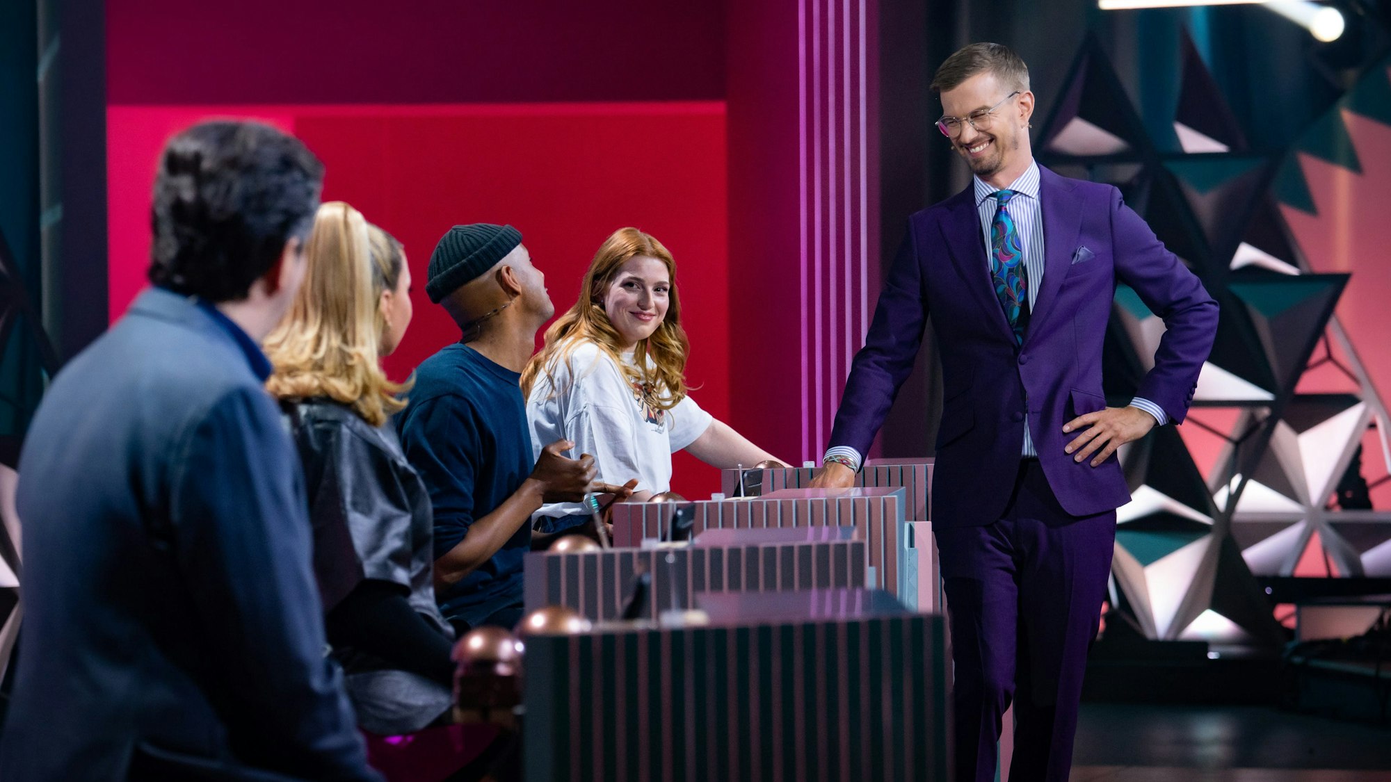 Die Kandidaten Bastian Pastewka, Shirin David, Teddy Teclebrhan und Antonia sitzen am Ratepult, der Moderator Joko Winterscheidt steht lachend davor.