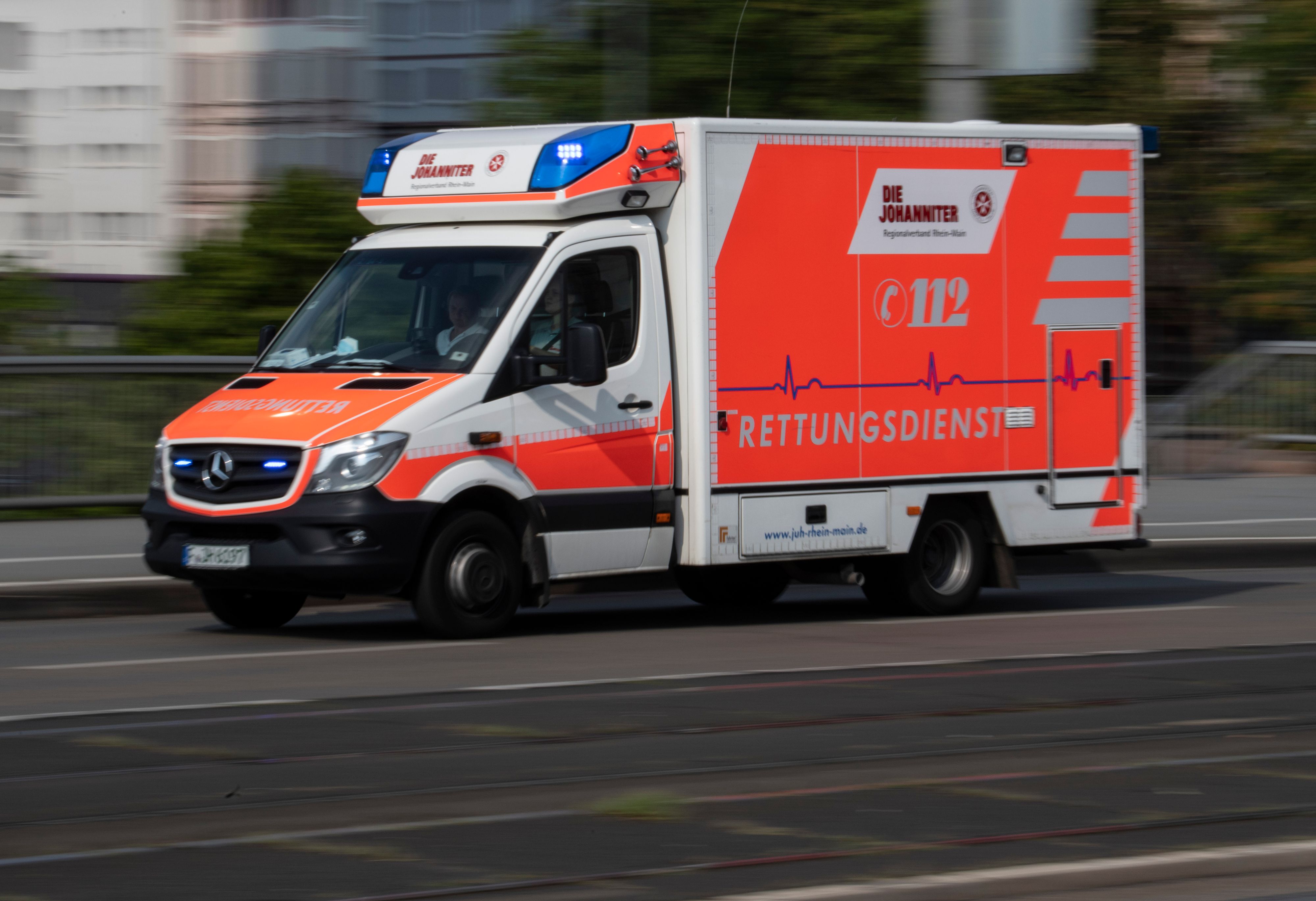 Mit eingeschaltetem Blaulicht fährt ein Rettungswagen über die Friedensbrücke zum Uniklinikum Frankfurt.
