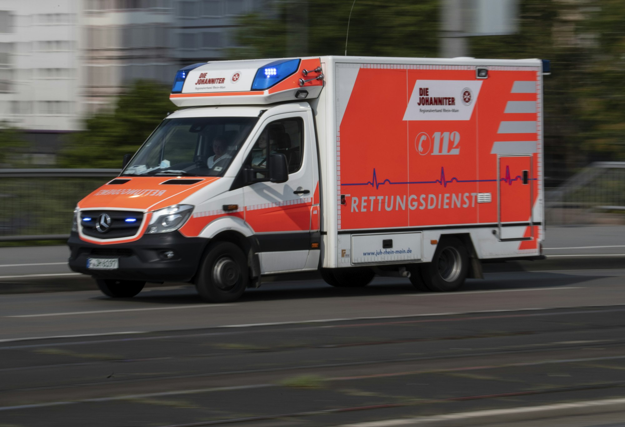 Mit eingeschaltetem Blaulicht fährt ein Rettungswagen über die Friedensbrücke zum Uniklinikum Frankfurt.