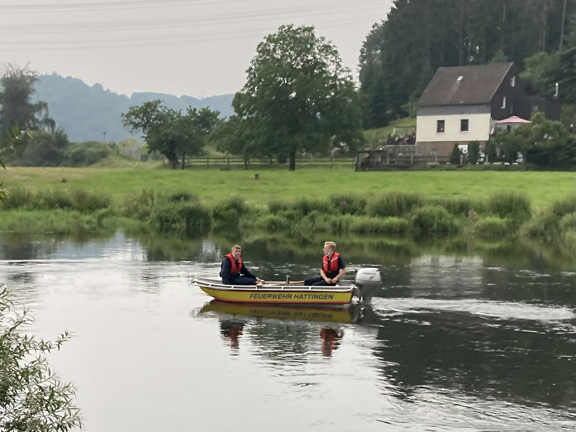 Zwei Personen sitzen auf einen Rettungsboot auf der Ruhr.