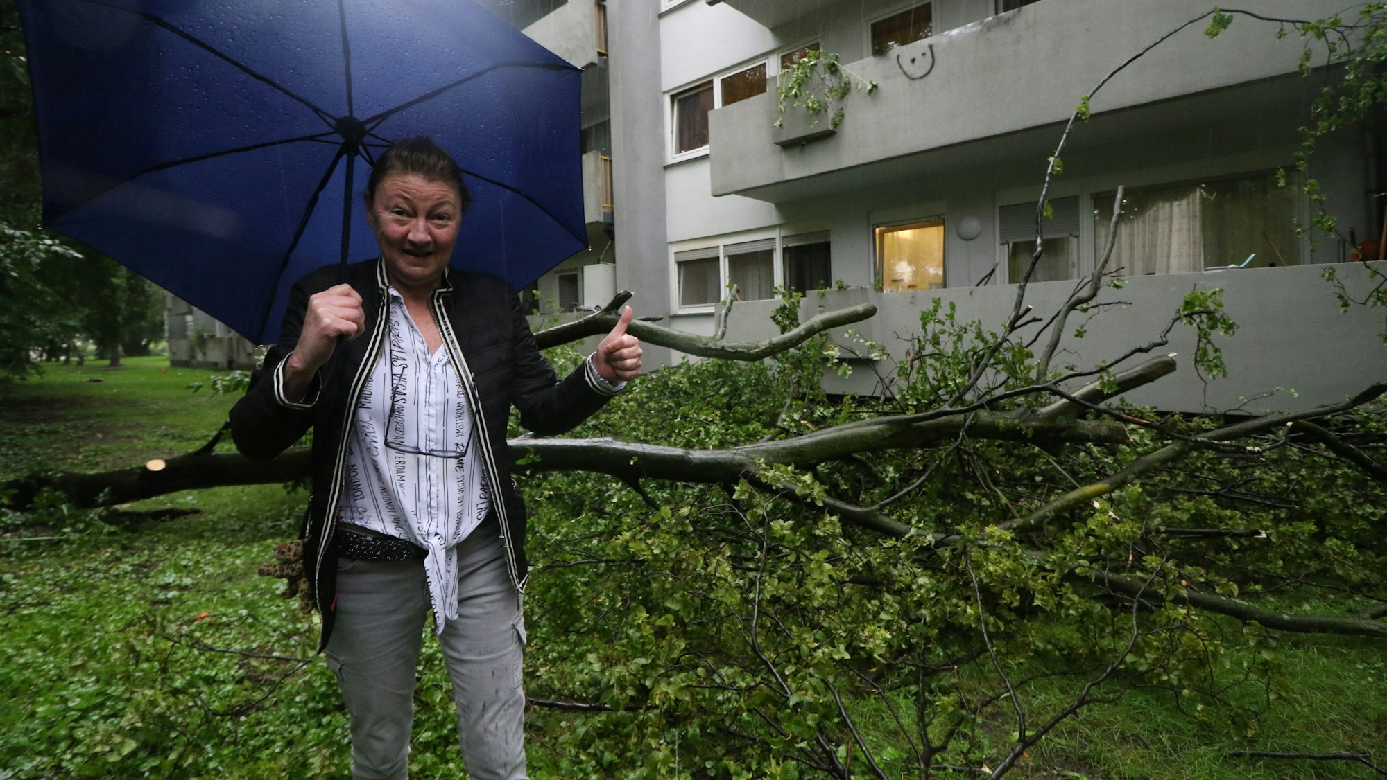 Die Kölnerin Sabina Meyer-Molnar steht neben einem Baum, der drohte, auf ihr Haus zu stürzen.