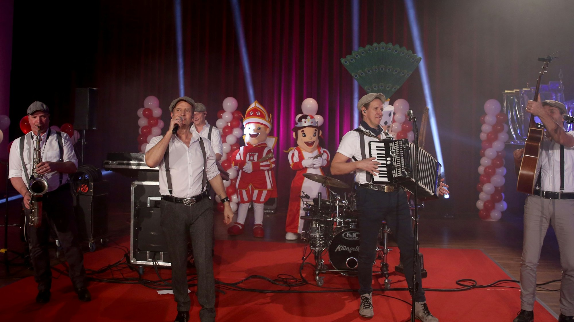 Die Klüngelköpp performen auf der Bühne während der Prinzenproklamation in Köln Porz.