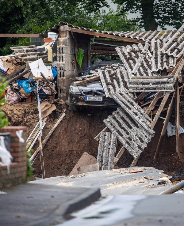 Ein Auto hängt im Ortsteil Blessem über einem Abgrund. Starkregen hatte am Mittwoch (14. Juli 2021) zu schweren Überschwemmungen und Hochwasser geführt.