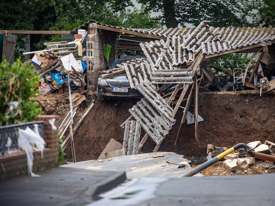 Ein Auto hängt im Ortsteil Blessem über einem Abgrund. Starkregen hatte am Mittwoch (14. Juli 2021) zu schweren Überschwemmungen und Hochwasser geführt.