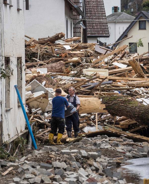 Zwei Männer packen am 15. Juli 2021 in Schuld im Ahrtal mit an