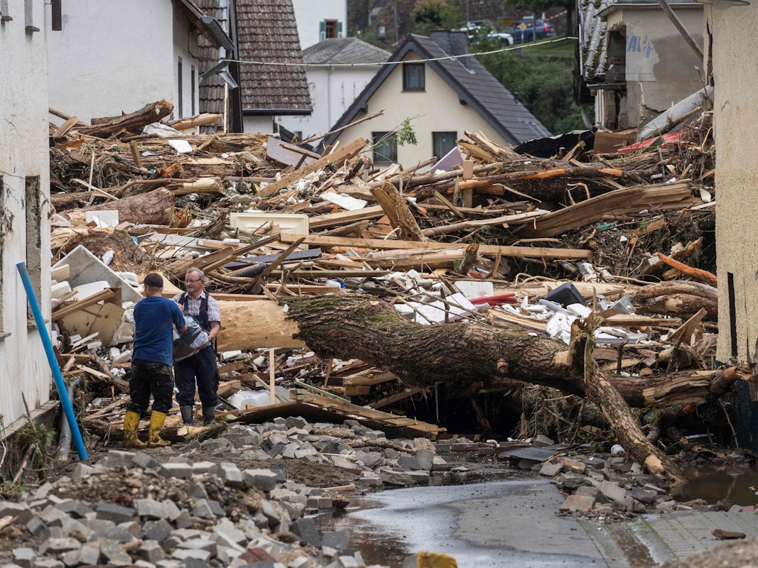 Zwei Männer packen am 15. Juli 2021 in Schuld im Ahrtal mit an