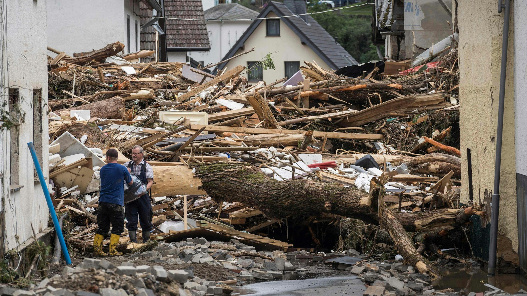 Zwei Männer packen am 15. Juli 2021 in Schuld im Ahrtal mit an
