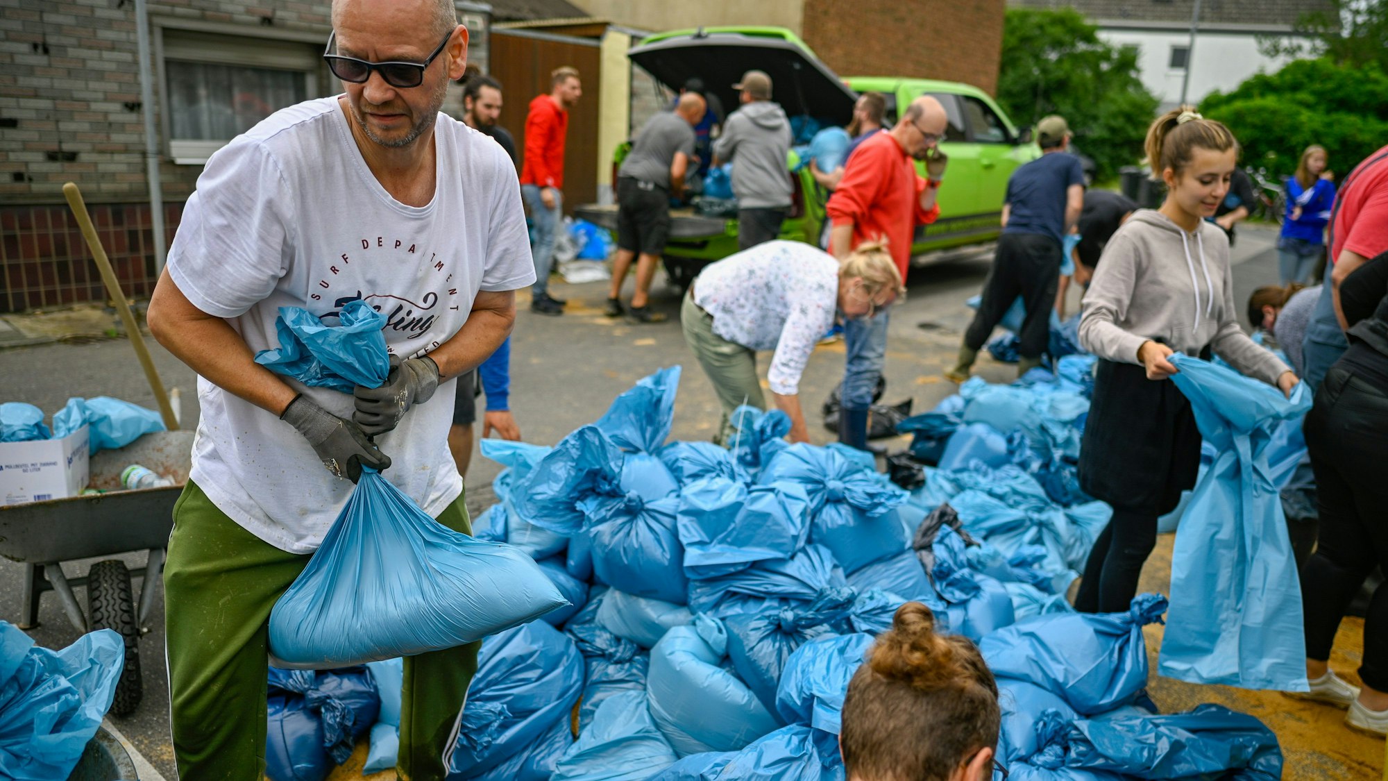 In Erftstadt füllen Freiwillige am 16. Juli 2021 Tüten mit Sand.