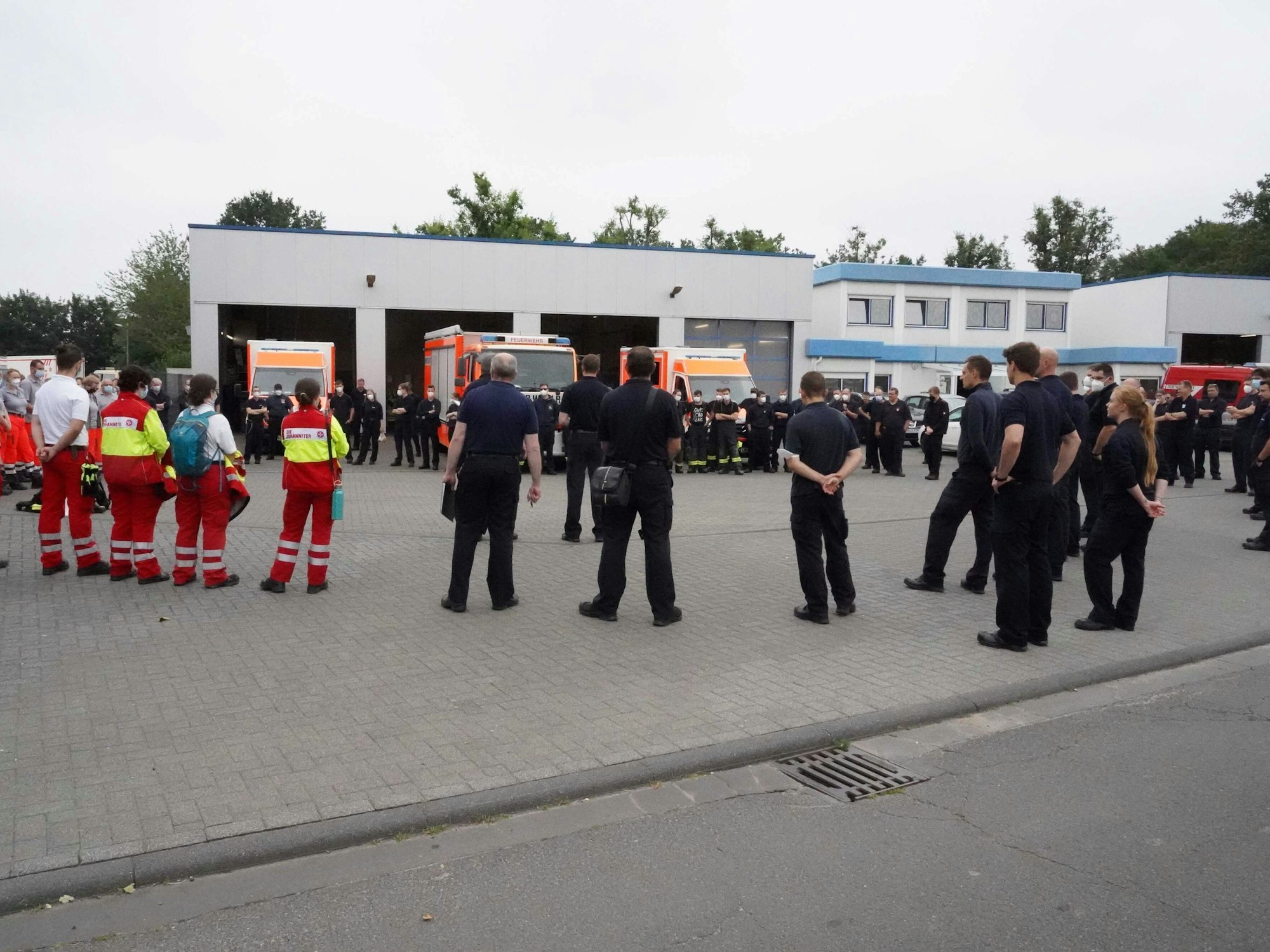 Einsatzkräfte der Feuerwehr besprechen die Hochwasser-Lage vor der Wache.