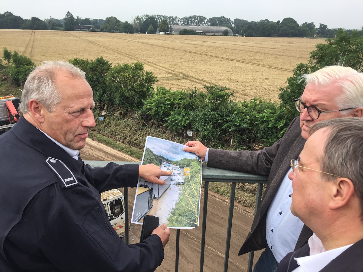 Feuerwehrmann Udo Milewski (links) erklärt NRW-Ministerpräsident Armin Laschet (vorne) und Bundespräsident Frank-Walter Steinmeier an der B265 im Ortsteil Liblar die Situation nach der Flutkatastrophe.