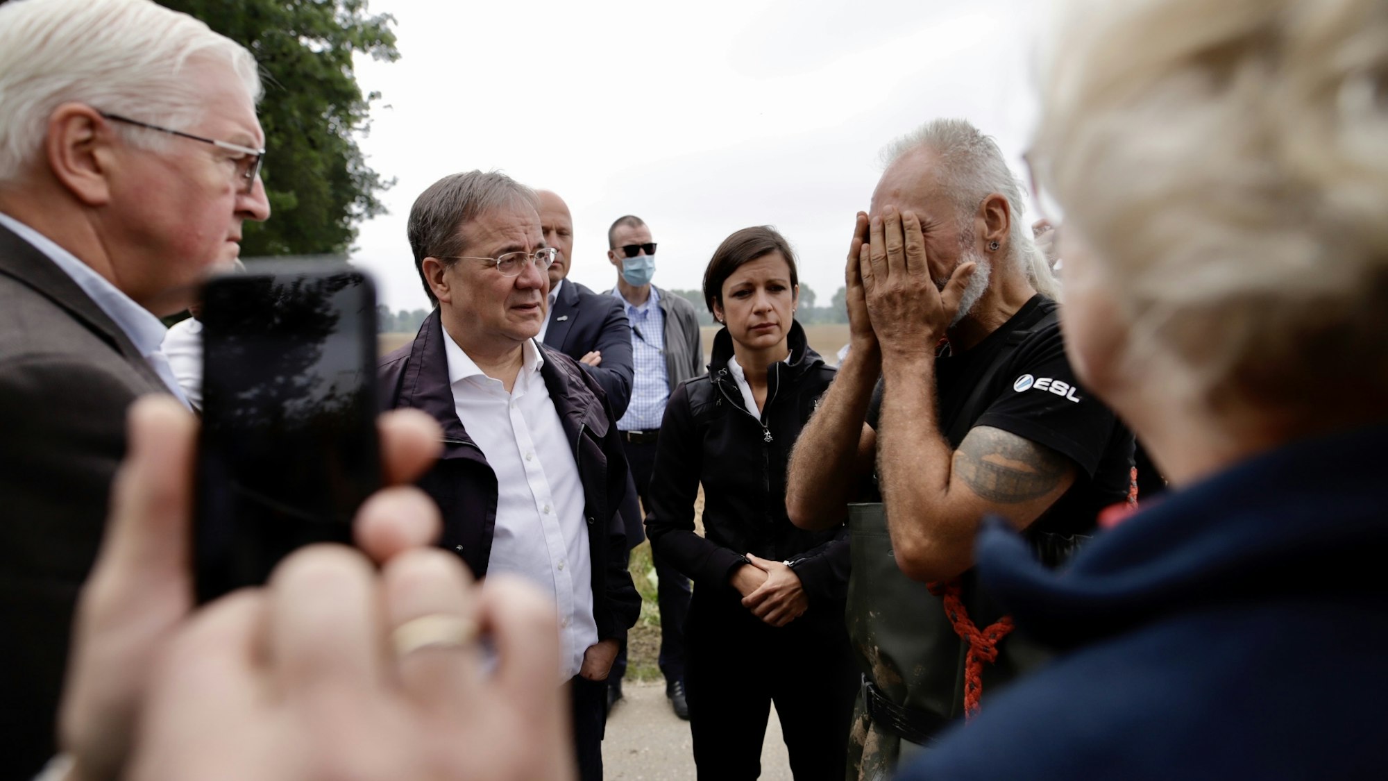Bundespräsident Frank-Walter Steinmeier und NRW-Ministerpräsident Armin Laschet (CDU) sprechen mit einem Anwohner in Erftstadt.