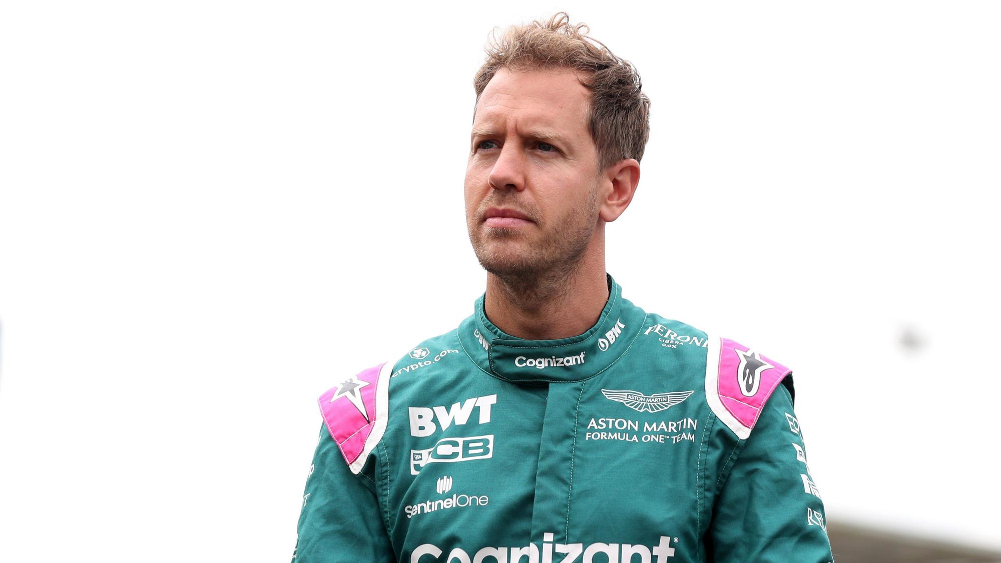 Sebastian Vettel geht im Rennanzug über die Strecke der Formel 1 in Silverstone.