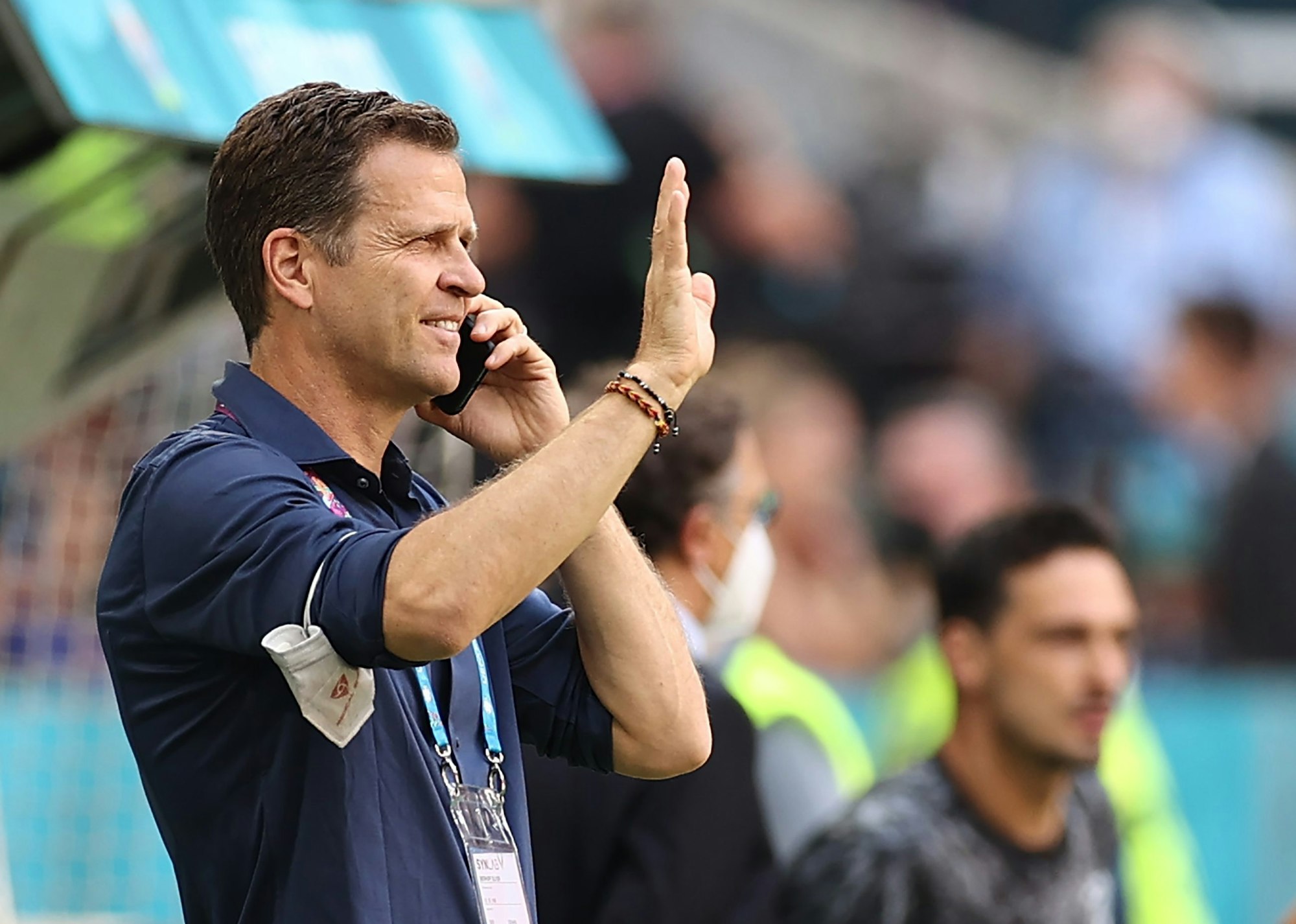 Oliver Bierhoff telefoniert und winkt